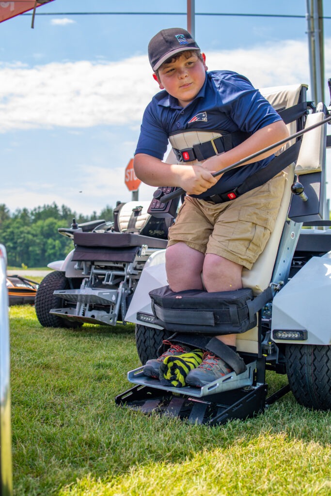 boy golfing in adaptive golf cart